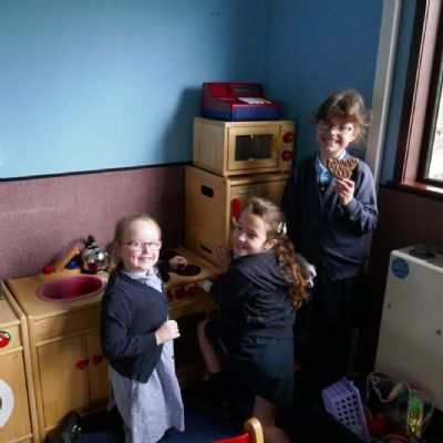 3 pupils playing with the kitchen