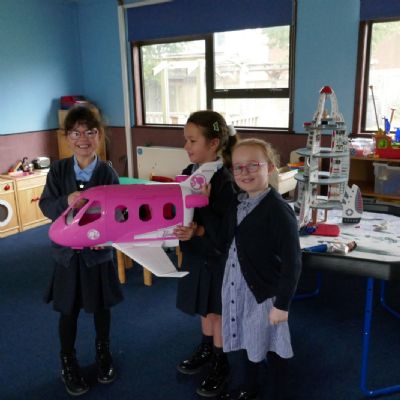 3 pupils playing with a Barbie plane