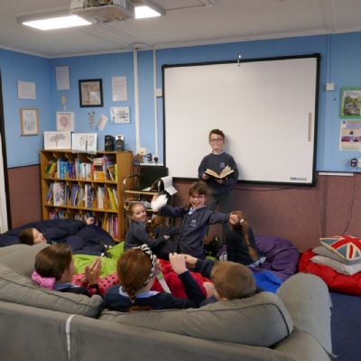 A pupil reading to their OofSC family