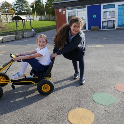 One pupil pushing another in a go cart