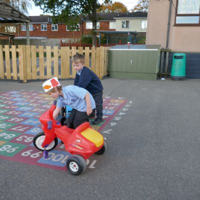 Two pupils playing on trikes