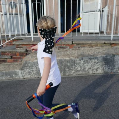One pupil playing with ribbon wands