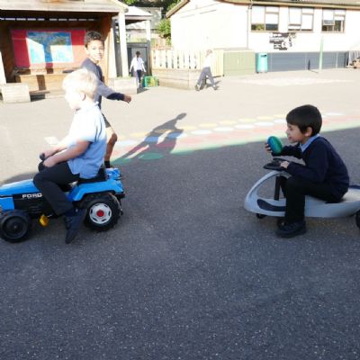 Two pupils racing on trikes