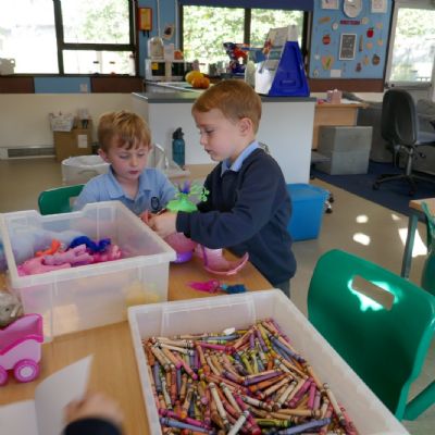 Two pupils playing with a pink toy