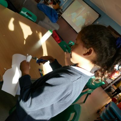 One pupil concentrating on cutting out